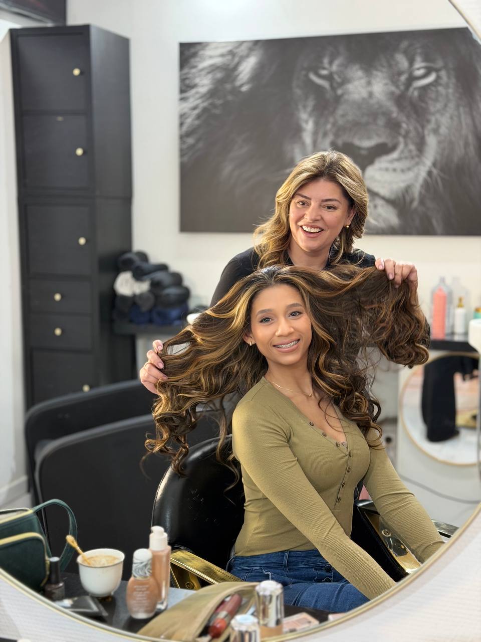 Coiffeuse coiffant des cheveux longs bouclés au salon